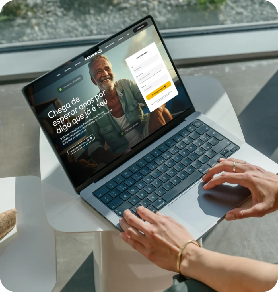 Laptop aberto exibindo o site do LCbank com um homem sorrindo.